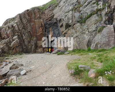 Besucher oder Pilger in Sankt Ninian's Cave, eine Pilgerstätte für Christen in der Nähe von Whithorn, Wigtownshire, Schottland (fotografiert 2019) Stockfoto