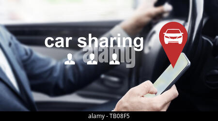 Mann fährt Auto und über mobile App von Vermietung Service Stockfoto