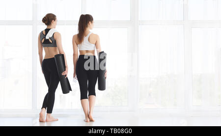 Zwei Frauen bleiben in der Nähe der Fenster nach Yoga Ausbildung Stockfoto