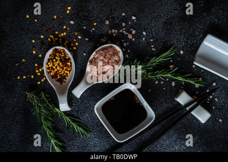 Tabelle Einstellung im asiatischen Stil mit Stäbchen und Gewürzen auf grauem Hintergrund mit Kopie Raum Stockfoto