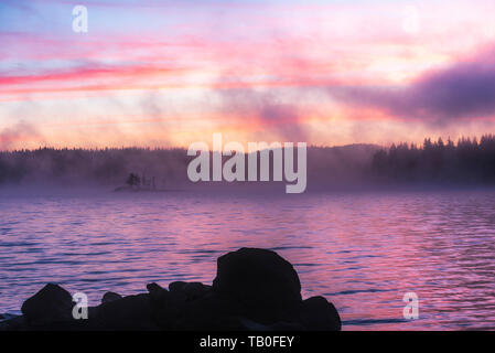Atemberaubende Bild von den nebligen See. Dramatischer Sonnenaufgang Szene. Stockfoto