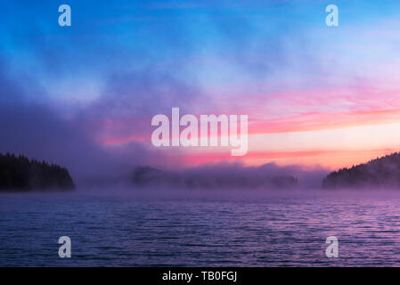 Atemberaubende Bild von den nebligen See. Dramatischer Sonnenaufgang Szene. Stockfoto