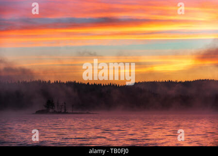 Atemberaubende Bild von den nebligen See. Dramatischer Sonnenaufgang Szene. Stockfoto