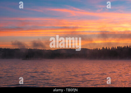 Atemberaubende Bild von den nebligen See. Dramatischer Sonnenaufgang Szene. Stockfoto