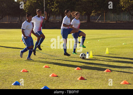 Weibliche Fußball-Spieler tun, Warm-up-Training auf dem Feld Stockfoto