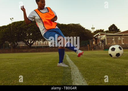 Fußball-Spieler kicken Kugel von markierungslinie am Sportplatz. Stockfoto