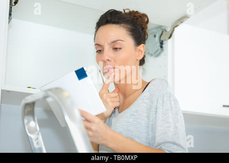 junge Frau Lesung Anweisungen Stockfoto