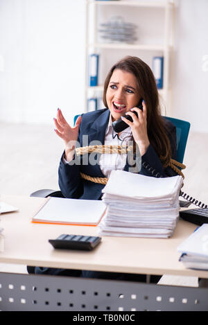 Junge schöne Mitarbeiter gebunden mit Seil im Büro Stockfoto