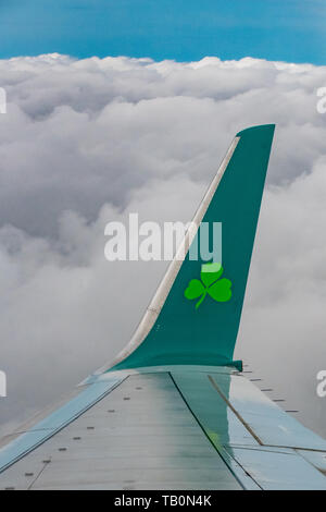 Aer Lingus A320 Flugzeugflügel über den Wolken - Aer Lingus Logo - Flugzeug über den Wolken - flugzeugflügel in Wolken Stockfoto