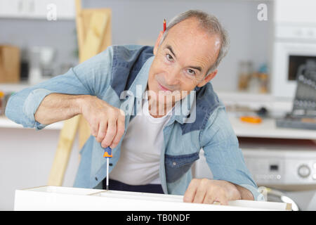 Zufrieden Tischler Anziehen der Schrauben Stockfoto