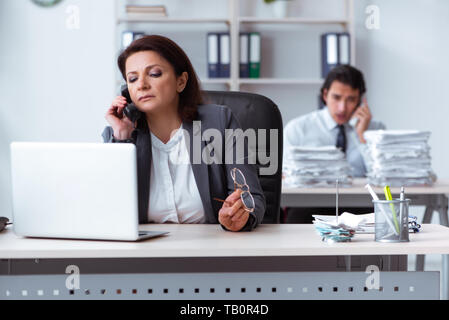 Alte Frau Boss und junge männliche Mitarbeiter im Büro Stockfoto