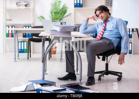 Die männlichen Mitarbeiter mit übermäßiger Arbeit unzufrieden Stockfoto