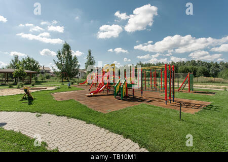 Spielplatz im Sommer. Baby schaukeln und Bänke auf einem Spielplatz an einem sonnigen Tag gesehen Stockfoto