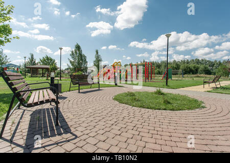 Spielplatz im Sommer. Baby schaukeln und Bänke auf einem Spielplatz an einem sonnigen Tag gesehen Stockfoto