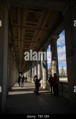 Touristen an der Kolonnade neben der Alten Nationalgalerie (Alte Nationalgalerie) an einem sonnigen Tag. Es ist auf der Museumsinsel in Berlin. Stockfoto