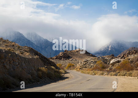 Straße in den Alabama Hills, in den Ausläufern der Sierra Nevada in Kalifornien - Nachmittag Sonne mit Nebel und trübe Wolken um die Berge Stockfoto