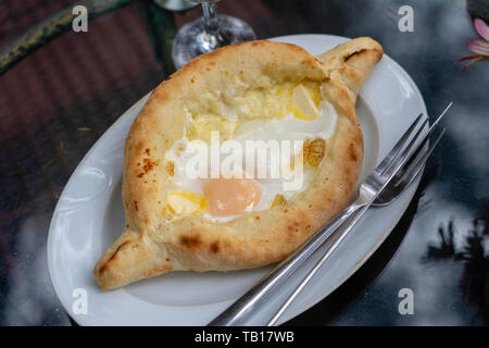 Adjarian khachapuri im Restaurant. Öffnen Brot Kuchen mit Käse und Eigelb. Lecker georgische Küche. Nahaufnahme Stockfoto