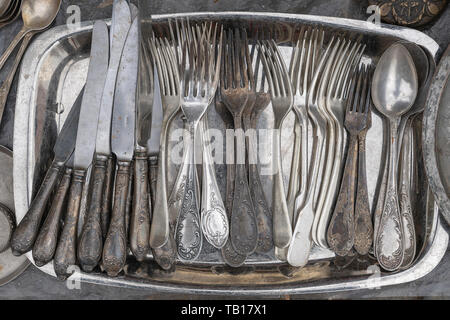 Alte Löffel, Gabeln, Messer an einem Metallauflagefach und auf einem Flohmarkt verkauft, Ansicht von oben, in der Nähe Stockfoto