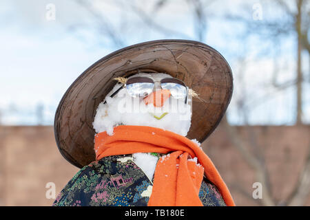 Schneemann in asiatische Kleidung, Sonnenbrille und Strohhut im Hof. Nahaufnahme Stockfoto