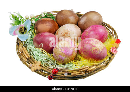 Handgefertigte Osternest mit ländlichen huhn bio Eier, die mit natürlichen Farbstoffen - Rüben, Kohl, Zwiebeln bemalt sind. Isolierte studio Makro Stockfoto