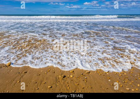 Wildwasser-Flutung auf einen Sandstrand Stockfoto