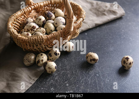 Weidenkorb mit Wachteleier auf Tisch Stockfoto