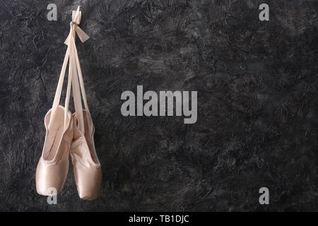 Hängende Ballett Schuhe auf dunklen Wand Stockfoto