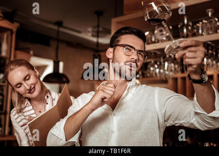 Aufmerksame bärtige männliche Person im Glas suchen Stockfoto