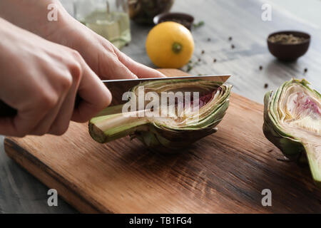 Frau bereitet leckere rohe Artischocken, Nahaufnahme Stockfoto