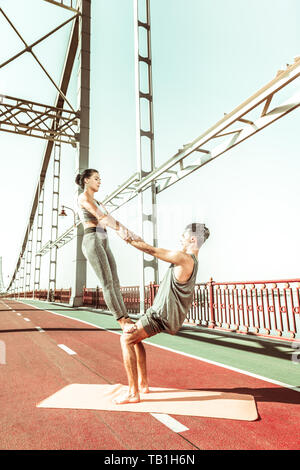 Zwei yogis Tun einer Oberschenkel stand acroyoga darstellen Stockfoto