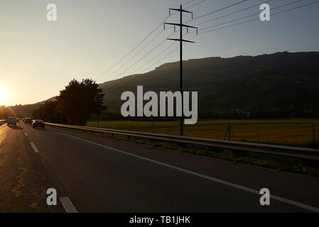 POV aus dem Auto mit Blick auf die Autobahn bis zu den hohen Bergen in der Schweiz Stockfoto
