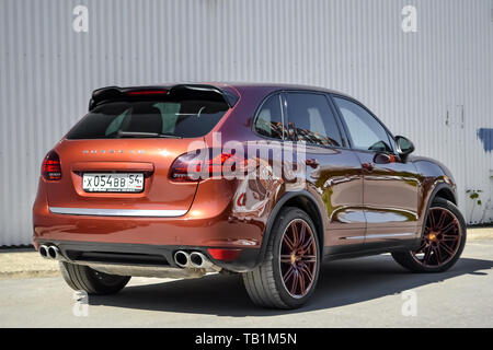 Nowosibirsk, Russland - 05.29.2019: Rückansicht der Porsche Cayenne 958 2013 in brauner Farbe nach der Reinigung vor dem Verkauf an einem sonnigen Sommertag mit Grau Stockfoto