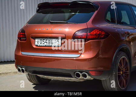 Nowosibirsk, Russland - 05.29.2019: Rückansicht der Porsche Cayenne 958 2013 in brauner Farbe nach der Reinigung vor dem Verkauf an einem sonnigen Sommertag mit Grau Stockfoto