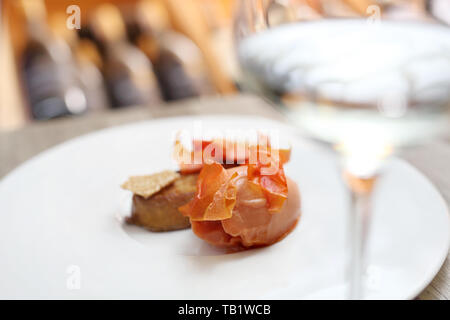 Eine exquisite und elegante Dessert serviert mit einem Glas Weißwein Stockfoto