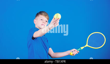 Tennis Sport und Unterhaltung. Junge Kind Tennis spielen. Tennis Fähigkeiten zu üben. Kerl mit Schläger genießen Spiel. Zukünftige Meister. Träumen über Sport Karriere. Athlet kid Tennisschläger auf blauem Hintergrund. Stockfoto