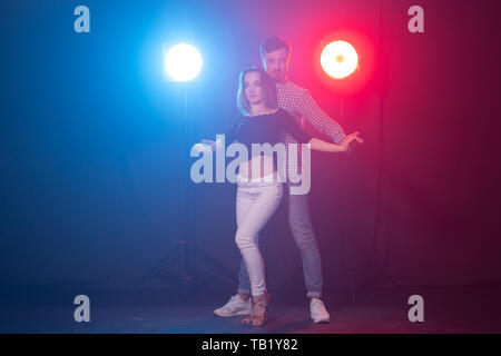 Social Dance, Kizomba und semba Konzept - junge schöne Paar tanzen Bachata und Salsa in der Dunkelheit Stockfoto