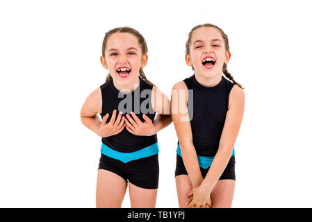 Portrait von Zwilling Mädchen in der Rhythmischen Gymnastik Kleid angezogen. Junge Zwillingsschwester Mädchen frontal Portrait im Tanzen sport Kleid. Mädchen sind smi Stockfoto