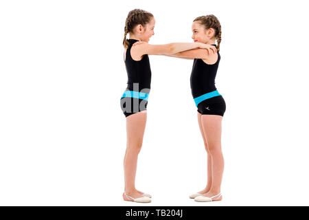 Zwilling Mädchen üben und tun, rhythmische Gymnastik, weißen Hintergrund. Junge Schwester Mädchen tanzen und Spaß haben die rhythmischen gymna Stockfoto