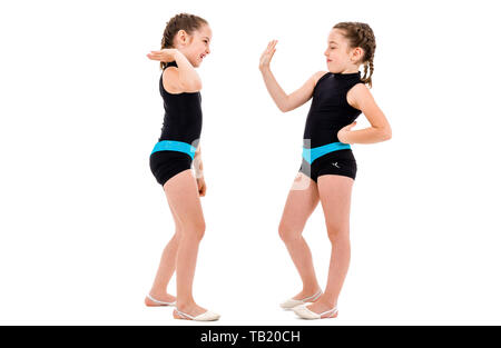 Zwilling Mädchen üben und tun, rhythmische Gymnastik, weißen Hintergrund. Junge Schwester Mädchen tanzen und Spaß haben die rhythmischen gymna Stockfoto