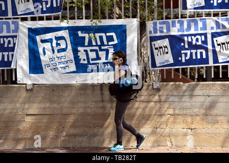 Tel Aviv, Israel. 9 Apr, 2019. Eine Frau geht letzten Wahl Banner in der Nähe eines Wahllokals in Tel Aviv, Israel Israel einer nationalen Wahl halten, nachdem Premierminister Benjamin Netanjahu konnte eine Koalitionsregierung mit ehemaligen Verteidigungsminister, Avigdor Lieberman zu errichten. Credit: Ronen Tivony/SOPA Images/ZUMA Draht/Alamy leben Nachrichten Stockfoto