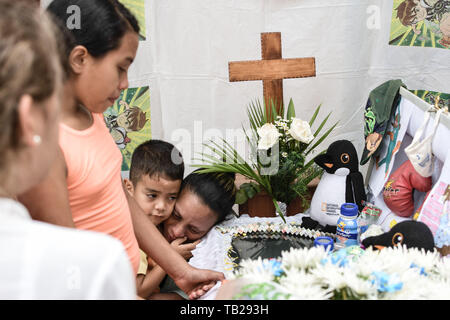 Caracas, Venezuela. 29 Mai, 2019. Die Mutter (R) mit ihren Söhnen nehmen an der Beerdigung von 11-jährigen Erick Altuve, in seinem Haus in der Nähe von Caracas Petare. Erick Altuve starb, während er darauf wartete, dass eine Transplantation von Knochenmark. Sechs venezolanische Kinder starben in einer Woche in einem öffentlichen Krankenhaus warten auf knochenmarktransplantationen. Regierung beschuldigt die Opposition trotz des Gesundheitswesens durch Maduros Regierung kontrolliert wird. Credit: SOPA Images Limited/Alamy leben Nachrichten Stockfoto