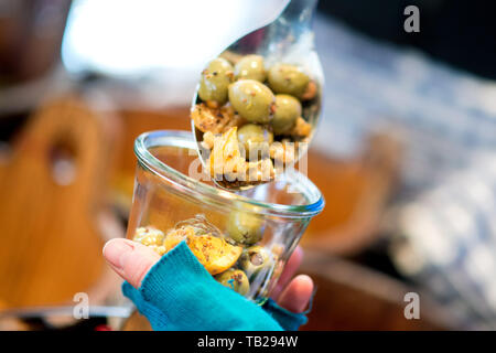 Oldenburg, Deutschland. 08 Mär, 2019. Eine Frau füllt eine wiederverwendbare Glas mit frischen Oliven auf einen Wochenmarkt. Mit dem wachsenden Umweltbewusstsein der Verbraucher, Verkäufer bei Wochenmärkten in Niedersachsen zunehmend auf nachhaltige Verpackungen Alternativen. Credit: Hauke-Christian Dittrich/dpa/Alamy leben Nachrichten Stockfoto