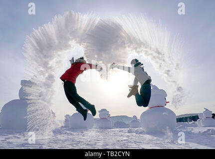 (190530) - HARBIN, 30. Mai 2019 (Xinhua) - Besucher spielen eine "Wasser zu Eis' Spiel durch Spritzwasser in das kalte Luft an Chinas nördlichster Beiji Dorf Mohe Stadt, im Nordosten der chinesischen Provinz Heilongjiang, Jan. 24, 2019. Im Nordosten von China, Provinz Heilongjiang ist weithin für seine ausgeprägte Jahreszeiten und seiner Bemühung, bekannte ökologische Entwicklung zu fördern, besonders in den grösseren und kleineren Khingan Berge. Die Waldfläche in der Khingan Berge, die als wichtiges Ökosystem Wald Funktion Zone und eine Reserve von strategischer Bedeutung für Schnittholz Ressourcen in China angesehen wird, Stockfoto