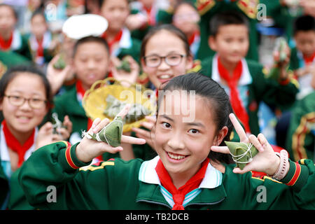 Yichang, Provinz Hubei in China. 30 Mai, 2019. Studenten Anzeige Zongzi, eine Art von Reis Knödel mit Bambusblätter gewickelt, auf eine Hoffnung Grundschule in Zigui Grafschaft von Yichang City, Chinas Provinz Hubei, 30. Mai 2019. Credit: Wang Gang/Xinhua/Alamy leben Nachrichten Stockfoto