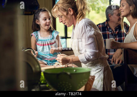 Reife Frau Kochen mit ihrer Enkelin in der Küche Stockfoto