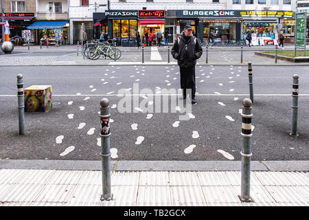 Schöneberg-Berlin. Älterer mann Kreuzung Fußgängerzone in der Maaßenstraße. Malte Spuren Kommen & Gehen Stockfoto