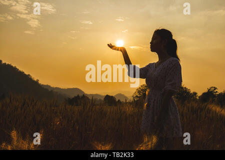 Silhouette der schöne junge Frau in der Gerste Feld weisse Sonne auf der Hand. Stockfoto