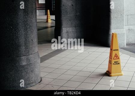 Ein Schilderkegel auf dem Boden mit der Aufschrift „NASSER BODEN“ Stockfoto