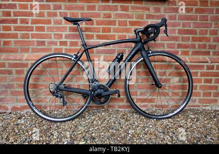 28 April 2019 - London, Vereinigtes Königreich: Elegante schwarze Fahrrad stehend gegen verwitterte Wand Stockfoto