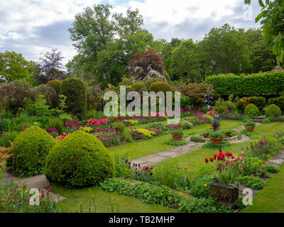 Chenies Manor versunkenen Garten mit Formschnitt, Pfad, Rasen und Zierpflanzen Teich; einem terrassierten Garten voller Farbe im Tulip Zeit. Gartengestaltung im Frühjahr. Stockfoto